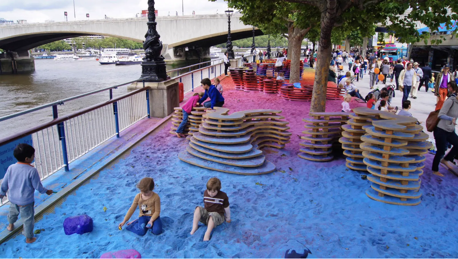 Rainbow Park on the South Bank in London, with coloured sand and climbing structures along the Thames.