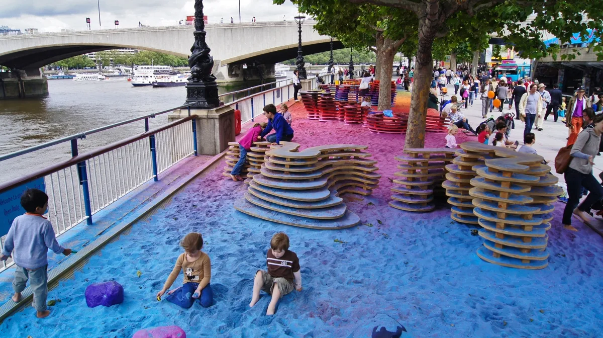 People interacting with the vivid colored sand of Rainbow Park.
