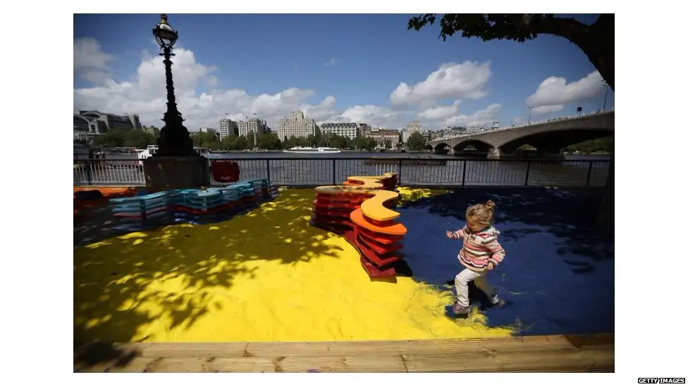 A child playing in the coloured sand of Rainbow Park at the Southbank Centre, London, 2012.